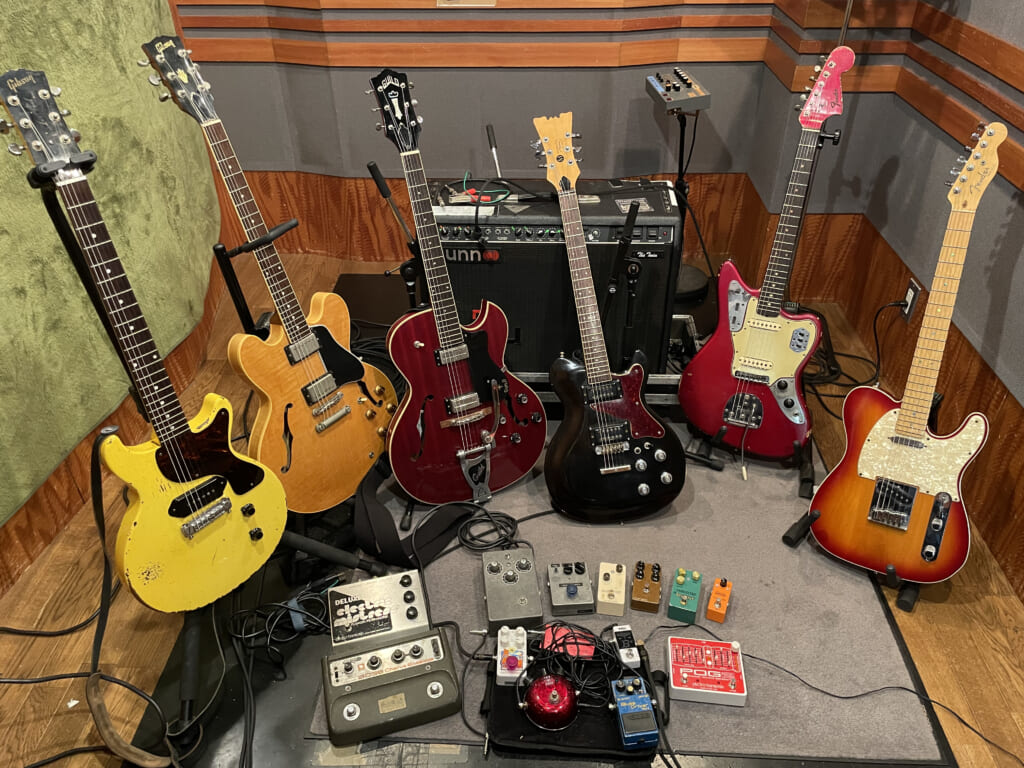 ギターのうしろにあるのがメイン・アンプのサンThe Twin。ギターは左からギブソン・カスタム・ショップ製1958 Les Paul Jr.、ギブソンES-335、ギルドStarfire III、モズライトModel 500 Blues  Bender、フェンダーJaguar、フェンダーAmerican Deluxe Telecaster。