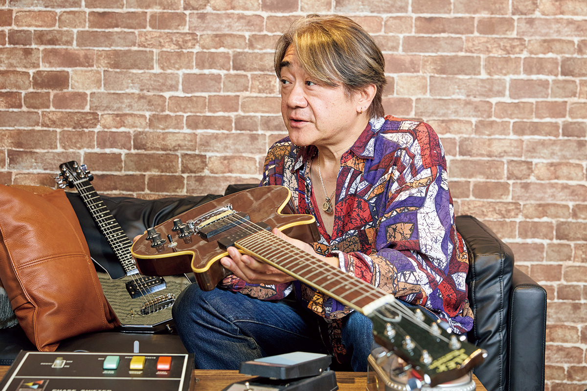 Alex Guitarを持つ野村。